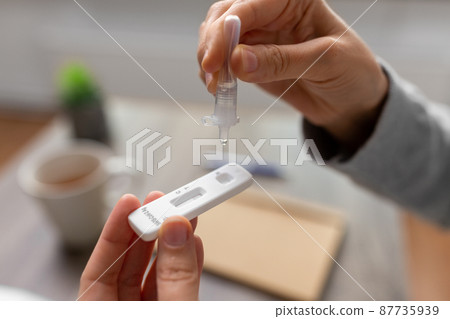 woman making self testing coronavirus test at home 87735939