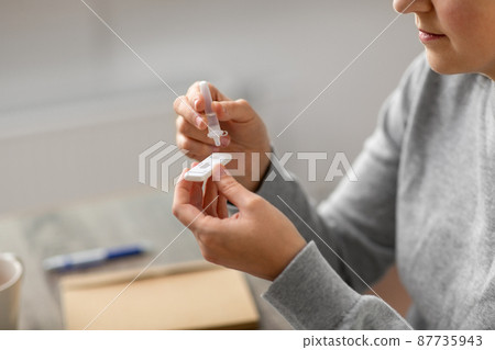 woman making self testing coronavirus test at home 87735943
