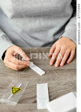 woman making self testing coronavirus test at home 87735944