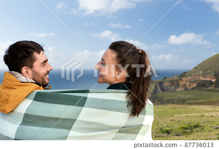happy couple in warm blanket in california 87736013