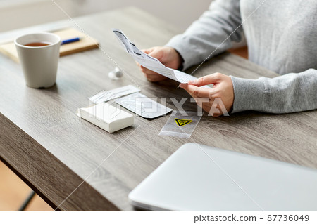 woman reading coronavirus test manual at home 87736049