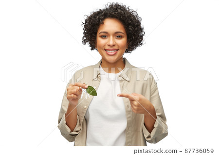 woman holding house keys with green leaf 87736059