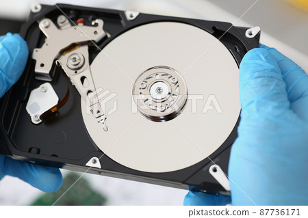 Handyman hold disassembled hard drive from computer, hdd and reader 87736171