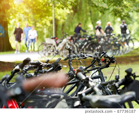 Bicycles parked in a park, exposed by selective focus Bicycles parked in a park, exposed by selective focus 87736187