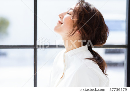 A woman by the window A woman by the window 87736579