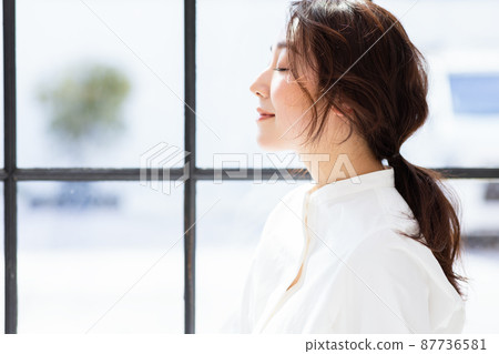 A woman by the window A woman by the window 87736581