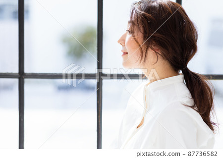 A woman by the window A woman by the window 87736582