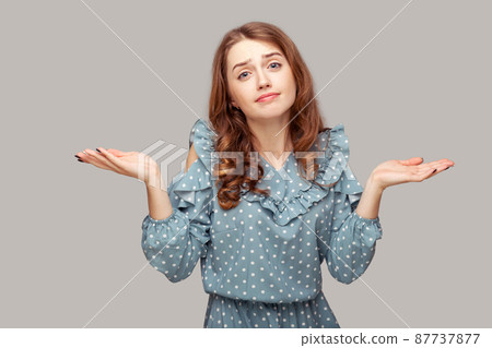 I don't know. Confused brunette girl ruffle dress shrugging shoulders embarrassed looking at camera, doubting answer, clueless uncertain expression. indoor studio shot isolated on gray background I don't know. Confused brunette girl ruffle dress shrugging shoulders embarrassed looking at camera, doubting answer, clueless uncertain expression. indoor studio shot isolated on gray background 87737877