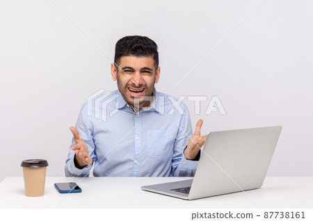 What do you want. Annoyed businessman, angry boss sitting in office, raising hands indignant irritated looking at camera, misunderstanding at work. indoor studio shot isolated on white background What do you want. Annoyed businessman, angry boss sitting in office, raising hands indignant irritated looking at camera, misunderstanding at work. indoor studio shot isolated on white background 87738161
