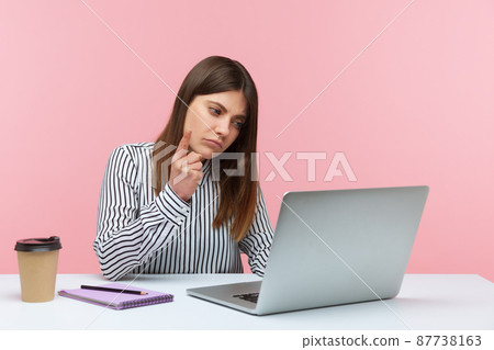 Be careful. Bossy woman office worker in striped shirt looking at laptop screen and warning finger, giving advice on video call, online conference. Indoor studio shot isolated on pink background Be careful. Bossy woman office worker in striped shirt looking at laptop screen and warning finger, giving advice on video call, online conference. Indoor studio shot isolated on pink background 87738163