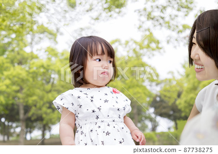 A young girl with a tired face playing with her mother against the backdrop of fresh green trees. Image of childcare, education, education, discipline A young girl with a tired face playing with her mother against the backdrop of fresh green trees. Image of childcare, education, education, discipline 87738275