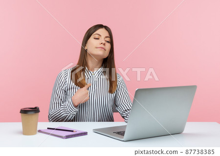 This is me. Self confident egoistic business woman pointing herself and looking at laptop display with arrogant expression, working in office. Indoor studio shot isolated on pink background This is me. Self confident egoistic business woman pointing herself and looking at laptop display with arrogant expression, working in office. Indoor studio shot isolated on pink background 87738385