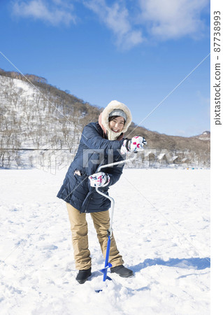 一位在湖冰上鑽洞的女人釣魚的圖片 一位在湖冰上鑽洞的女人釣魚的圖片 87738993