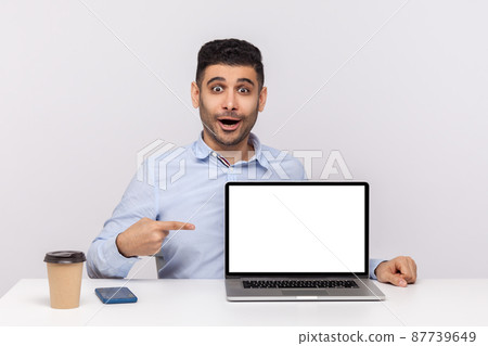 Wow, look at advertisement. Amazed man employee sitting in office workplace, pointing laptop blank display and looking surprised shocked expression, mock up for website promotion. studio shot isolated Wow, look at advertisement. Amazed man employee sitting in office workplace, pointing laptop blank display and looking surprised shocked expression, mock up for website promotion. studio shot isolated 87739649