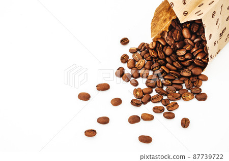 Paper bag with grain coffee on white background. coffee beans isolated on white background. roasted coffee beans, can be used as a background. Paper bag with grain coffee on white background. coffee beans isolated on white background. roasted coffee beans, can be used as a background. 87739722