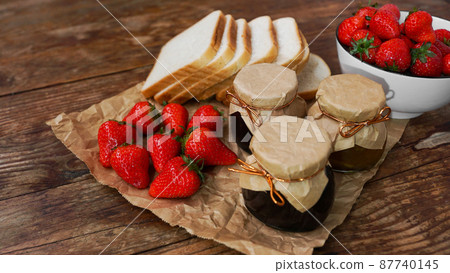 Slices of bread and delicious strawberry jam jar and fresh berries on wooden 87740145