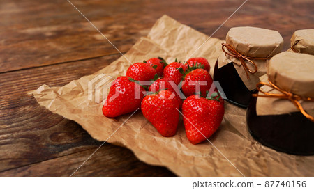 Strawberry jam in the glass jar with fresh berries on wooden background 87740156