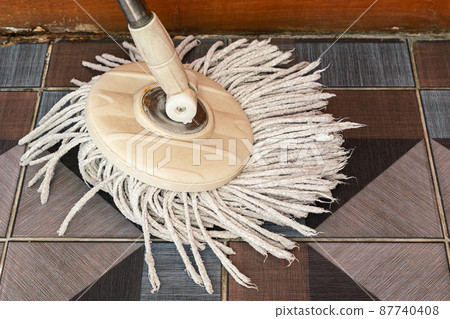 View of used cleaning mop with micro fiber on ceramic tile floor. View of used cleaning mop with micro fiber on ceramic tile floor. 87740408