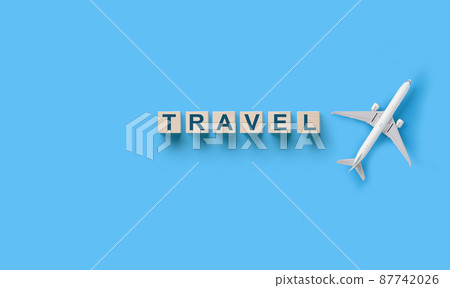 Traveling concept , wooden cubes with TRAVEL word and toy airplane 87742026