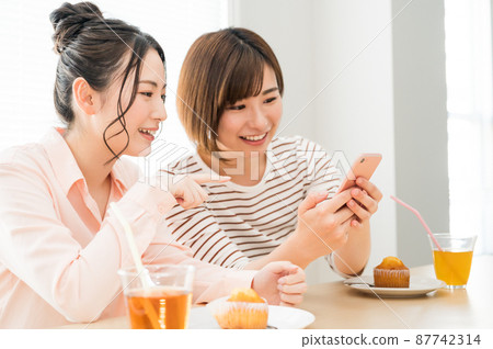 一個女人一起看智能手機 一個女人一起看智能手機 87742314