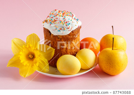 Easter cake, eggs and daffodil flower on pink background. Easter cake, eggs and daffodil flower on pink background. 87743088