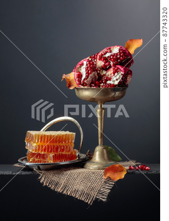 Ripe pomegranate fruits with  honey. 87743320