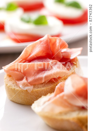 Italian appetizer bruschetta with Parma ham on a plate Italian appetizer bruschetta with Parma ham on a plate 87743362