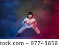 5-year-old elementary school girl, in kimono, practicing martial arts among smoke and colored lights. 87743858