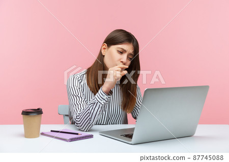 Disappointed woman office worker showing a little bit gesture to laptop screen, talking on video call, measuring minimum scale. Indoor studio shot isolated on pink background 87745088