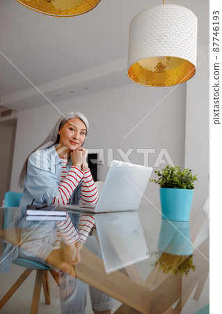 Woman using modern notebook in living room 87746193