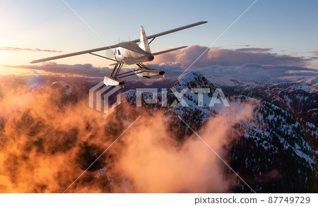 Single Engine Seaplane Flying over the Rocky Mountain Landscape. 87749729
