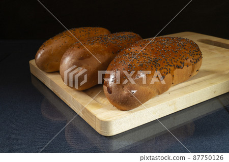 Bread on table with reflection on black background 87750126