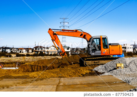 Construction work: Heavy equipment backhoe and clear blue sky 87750425