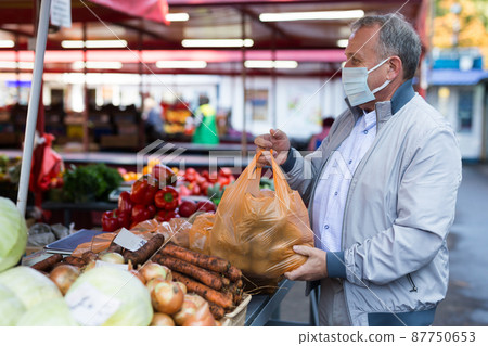 Middle aged man in mask buying potatoes Middle aged man in mask buying potatoes 87750653