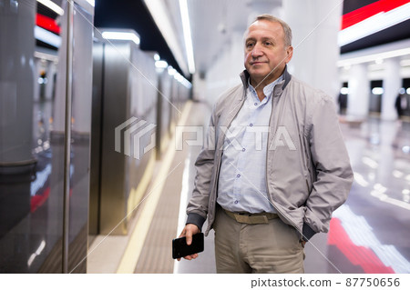 Middle aged man waiting for train in subway station Middle aged man waiting for train in subway station 87750656