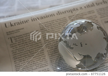 Glass globe and English newspaper (Ukraine situation) 87751126