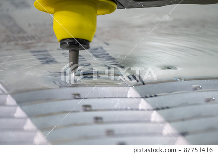 Closeup scene the multi-axis waterjet cutting machine with NC code data background. 87751416