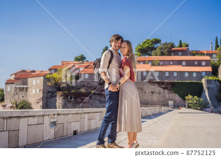 Man and woman tourists on background of beautiful view of the island of St. Stephen, Sveti Stefan on the Budva Riviera, Budva, Montenegro. Travel to Montenegro concept 87752125