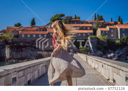Woman tourist on background of beautiful view of the island of St. Stephen, Sveti Stefan on the Budva Riviera, Budva, Montenegro. Travel to Montenegro concept 87752126
