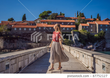 Woman tourist on background of beautiful view of the island of St. Stephen, Sveti Stefan on the Budva Riviera, Budva, Montenegro. Travel to Montenegro concept 87752127