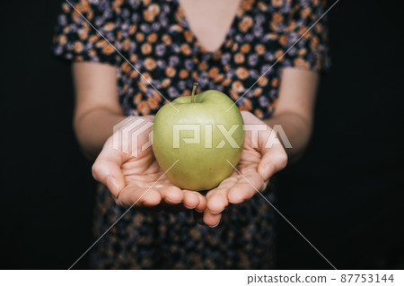 green apple in hands of woman green apple in hands of woman 87753144