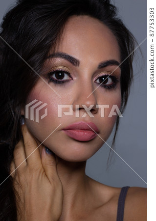 Beautiful brunet model woman face with brown eyes and perfect make-up . Portrait of beauty young brunet girl with pink lips. Female face with clear skin close-up. Skincare Beautiful brunet model woman face with brown eyes and perfect make-up . Portrait of beauty young brunet girl with pink lips. Female face with clear skin close-up. Skincare 87753303