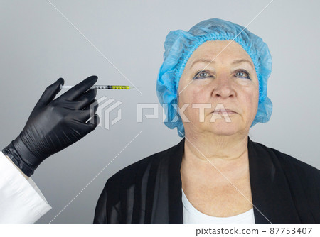 Botulinum toxin injection. Senior woman at the appointment with a beautician who is preparing to give anti-wrinkle injections. Loose skin and hypotension. Mimic wrinkles and contouring 87753407
