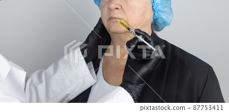 Botulinum toxin injection. Senior woman at the appointment with a beautician who is preparing to give anti-wrinkle injections. Loose skin and hypotension. Mimic wrinkles and contouring 87753411