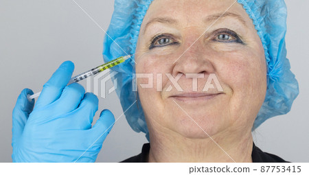 Botulinum toxin injection. Senior woman at the appointment with a beautician who is preparing to give anti-wrinkle injections. Loose skin and hypotension. Mimic wrinkles and contouring 87753415