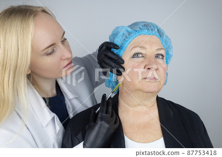 Botulinum toxin injection. Senior woman at the appointment with a beautician who is preparing to give anti-wrinkle injections. Loose skin and hypotension. Mimic wrinkles and contouring 87753418