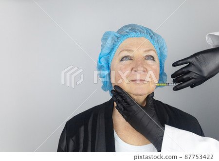 Botulinum toxin injection. Senior woman at the appointment with a beautician who is preparing to give anti-wrinkle injections. Loose skin and hypotension. Mimic wrinkles and contouring 87753422