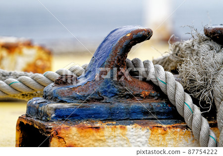 Close up of the boat bollard with a rope tied around 87754222