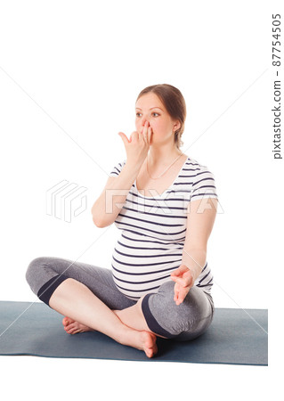 Pregnant woman doing yoga breathing exercise Pranayama 87754505