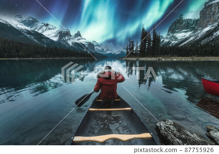 Beautiful aurora borealis over spirit island with male traveler on canoe at Jasper national park Beautiful aurora borealis over spirit island with male traveler on canoe at Jasper national park 87755926